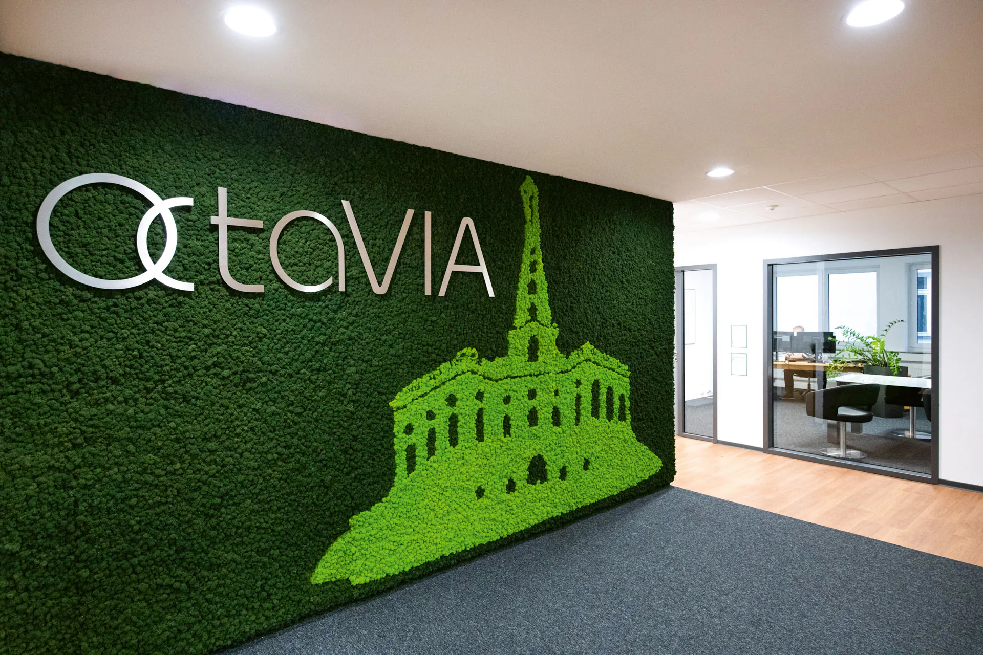 Cuadro de musgo con logotipo en la recepción de una oficina moderna
