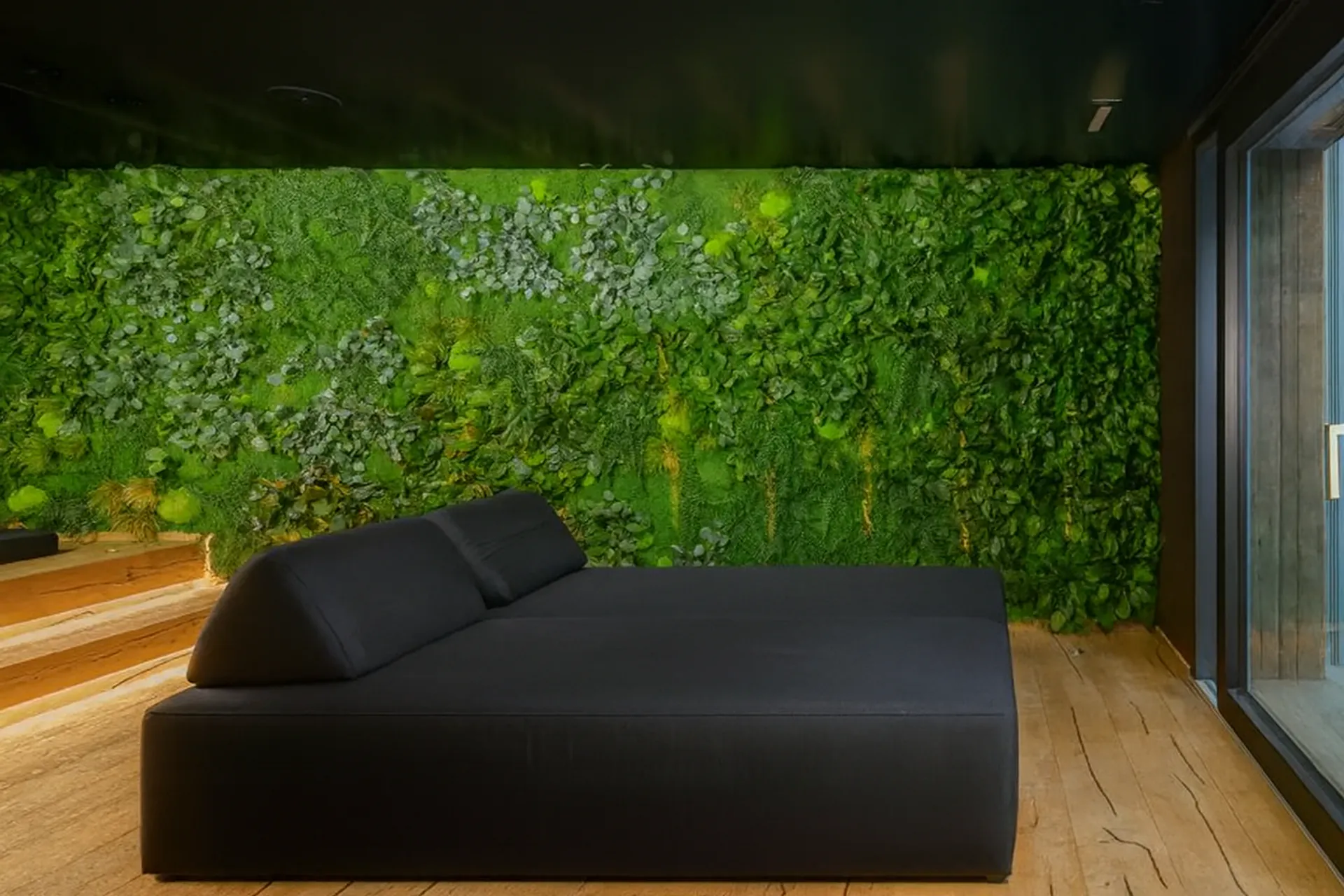 Pared de musgo «Relaxzone» con sofá negro — Decoración vegetal para paredes de MOOSMOOS